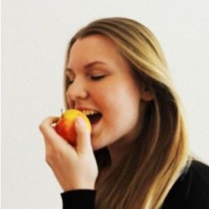 Frau beißt in Apfel rein-Zahnarzt im 8. Bezirk